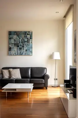 a living room with a black couch and a table at Uma Suites Passeig de Gracia 16 in Barcelona