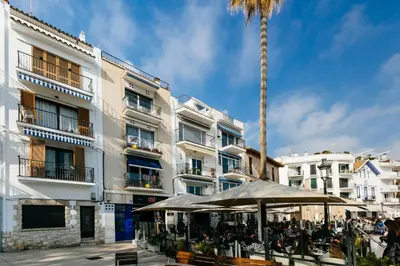 a group of people sitting in front of a building at Port alegre - en el corazón de Sitges in Sitges