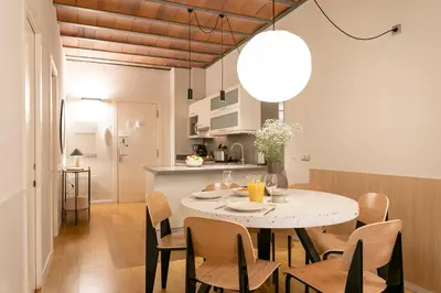a kitchen and dining room with a table and chairs at Aspasios Las Ramblas Apartments in Barcelona