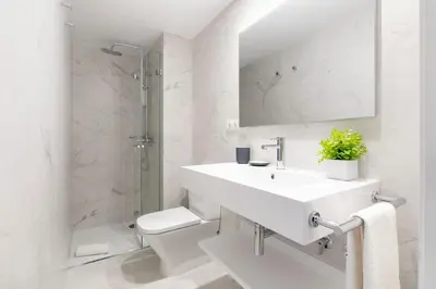 a white bathroom with a sink and a toilet at Aspasios Las Ramblas Apartments in Barcelona