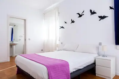 a bedroom with a bed with birds on the wall at Monrooms Barcelona in Barcelona