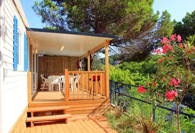 a porch of a house with a table and chairs at Camping Roca Grossa in Calella