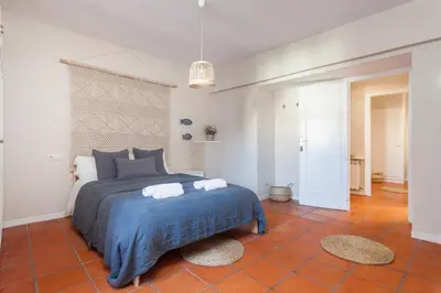 a bedroom with a bed with a blue blanket at La Casita - centro histórico y playa in Sitges