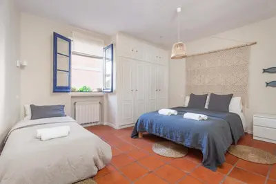a bedroom with two beds and a window at La Casita - centro histórico y playa in Sitges