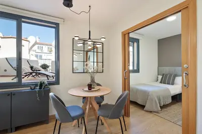 a room with a table and chairs and a bedroom at Apartments Barcelona & Home Deco Eixample in Barcelona