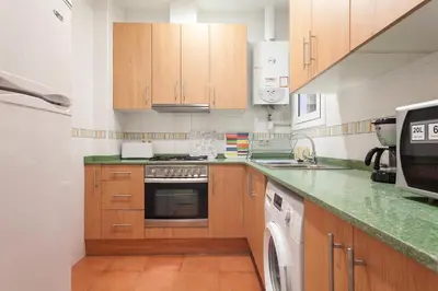 a kitchen with wooden cabinets and a stove top oven at Apartments Barcelona & Home Deco Eixample in Barcelona