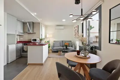 a kitchen and living room with a table and chairs at Apartments Barcelona & Home Deco Eixample in Barcelona