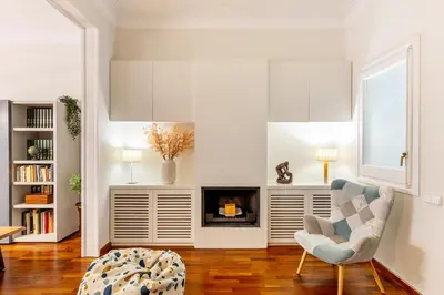 a living room with a chair and a fireplace at Large & beautiful apartment 4min from Passeig de Gràcia in Barcelona