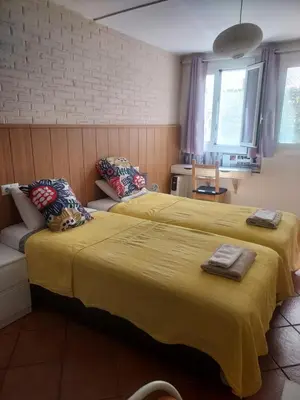 two beds sitting next to each other in a room at Barcelona Village Homestay in Tiana