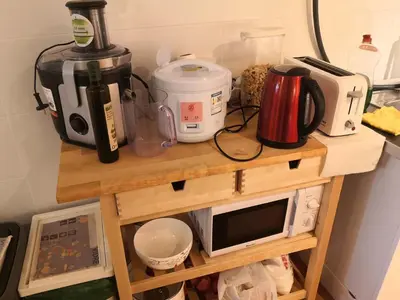 a table with a coffee maker and a microwave on it at Barcelona Village Homestay in Tiana