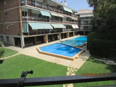 a large swimming pool in front of a building at Apart.con piscina en Sitges zona residencial in Sitges