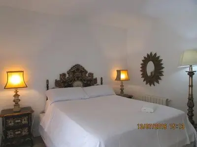 a bedroom with a large white bed with two lamps at Apart.con piscina en Sitges zona residencial in Sitges