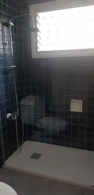 a bathroom with a shower with a toilet and a window at Apart.con piscina en Sitges zona residencial in Sitges