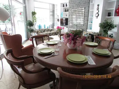 a dining room table with plates and flowers on it at Apart.con piscina en Sitges zona residencial in Sitges