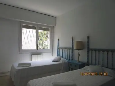 a white room with two beds and a window at Apart.con piscina en Sitges zona residencial in Sitges
