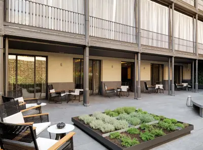 a courtyard with tables and chairs and a garden at H10 Urquinaona Plaza in Barcelona
