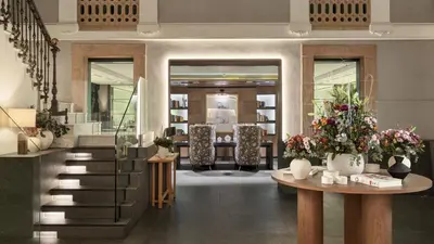 a lobby with a staircase and a table with flowers at H10 Urquinaona Plaza in Barcelona