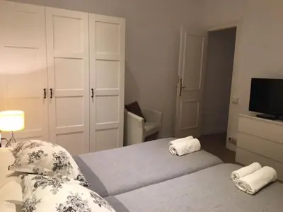 a bedroom with two beds and a tv and a couch at 555 Apartments BCN in Barcelona