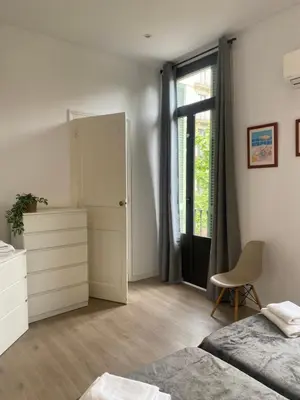 a bedroom with a bed and a dresser and a window at 555 Apartments BCN in Barcelona