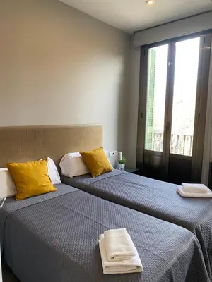 two beds sitting next to each other in a room at 555 Apartments BCN in Barcelona