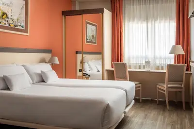 a hotel room with a large bed and a desk at Petit Palace Trencadís in Barcelona