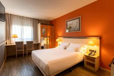 a hotel room with a bed and a desk at Petit Palace Trencadís in Barcelona