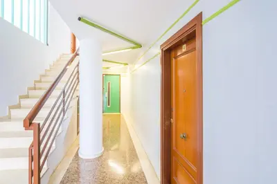 a hallway with stairs and a wooden door at HomeHolidaysRentals Frida in Pineda de Mar