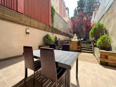 a wooden table and chairs on a patio at Home to Home Barcelona in Barcelona