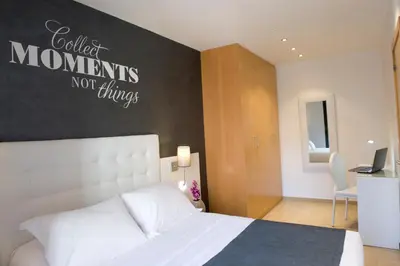 a bedroom with a white bed and a black wall at Home to Home Barcelona in Barcelona