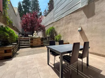 a table and chairs in a courtyard with a statue at Home to Home Barcelona in Barcelona