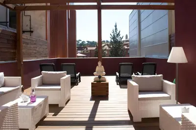 a patio with white chairs and tables and a large window at Home to Home Barcelona in Barcelona