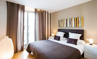 a bedroom with a large bed and a large window at Durlet Beach Apartments in Barcelona