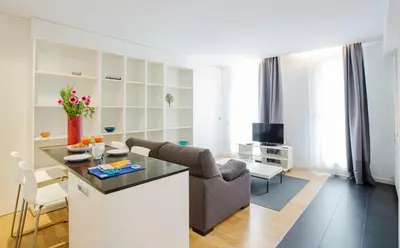 a kitchen and living room with a table and chairs at Durlet Beach Apartments in Barcelona