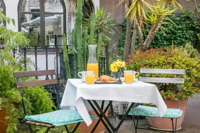 a table with a plate of food and orange juice at Mihlton Barcelona Boutique B&B in Barcelona