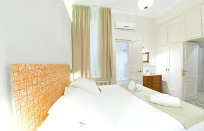 a white bedroom with a large bed and a brick wall at Mihlton Barcelona Boutique B&B in Barcelona