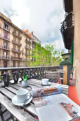 a table with two cups and a newspaper on a balcony at Mihlton Barcelona Boutique B&B in Barcelona