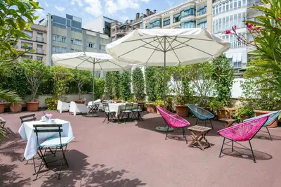 a patio with tables and chairs and umbrellas at Mihlton Barcelona Boutique B&B in Barcelona