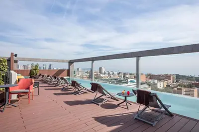 a rooftop deck with chairs and tables on a building at Acta Voraport in Barcelona