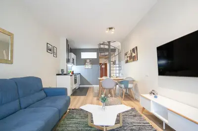 a living room with a blue couch and a table at Tendency Apartments 8 in Barcelona