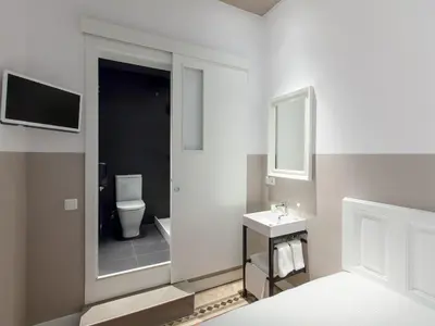 a bathroom with a toilet and a sink and a mirror at Ecozentric in Barcelona
