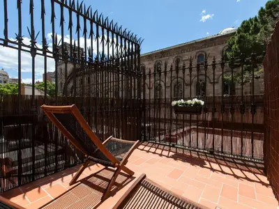 a chair sitting in front of a wrought iron fence at Ecozentric in Barcelona