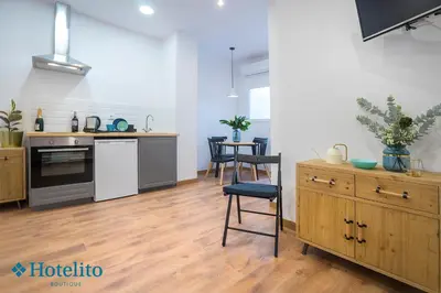 an open kitchen and dining room with a table and chairs at Hotelito Boutique Badalona Mar in Badalona