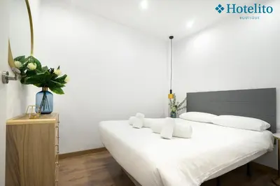 a bedroom with a bed with white sheets and pillows at Hotelito Boutique Badalona Mar in Badalona