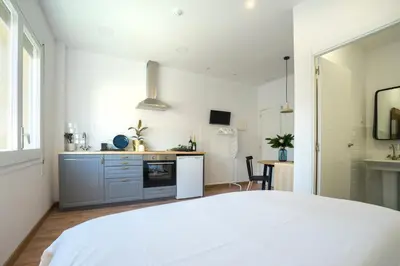 a white kitchen with a white bed in a room at Hotelito Boutique Badalona Mar in Badalona