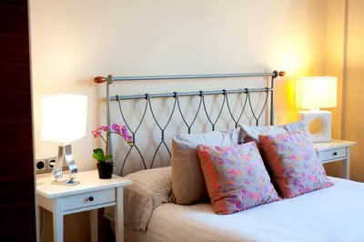 a bed with two pillows on it with two lamps at Alcam Barbera Terrazas in Barbera del Valles