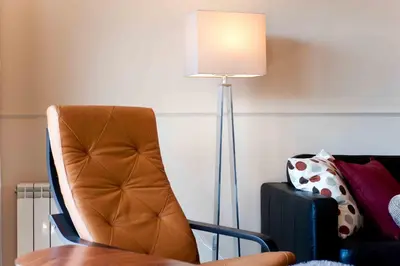 a brown chair next to a table with a lamp at Alcam Barbera Terrazas in Barbera del Valles