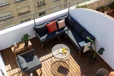 a balcony with a blue couch and a table at Casa Cosi - Atico in Barcelona