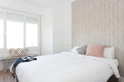 a bedroom with a large white bed and a window at Casa Cosi - Atico in Barcelona