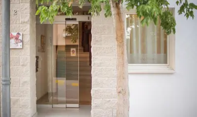 a glass door to a building with a tree at Sono Master Apartments in La Garriga