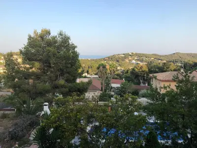 a view of a town with trees and the ocean at Casa Bella Vista en montaña con vistas al mar y piscina privada in Cunit